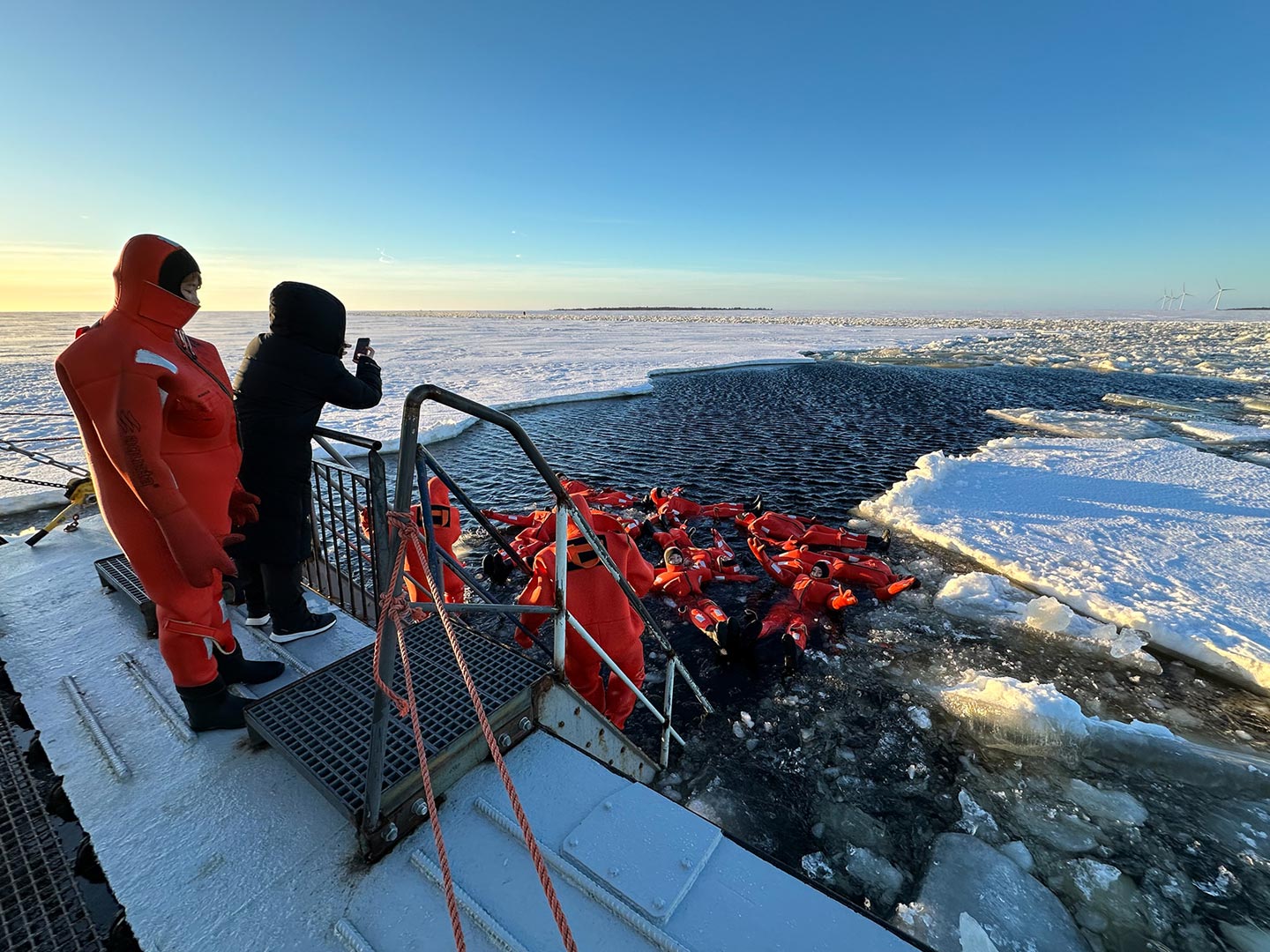 ice floating in the frozen baltic sea in lapland - group of people floating